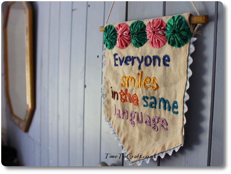 Embroidered banner. Everyone smiles in the same language